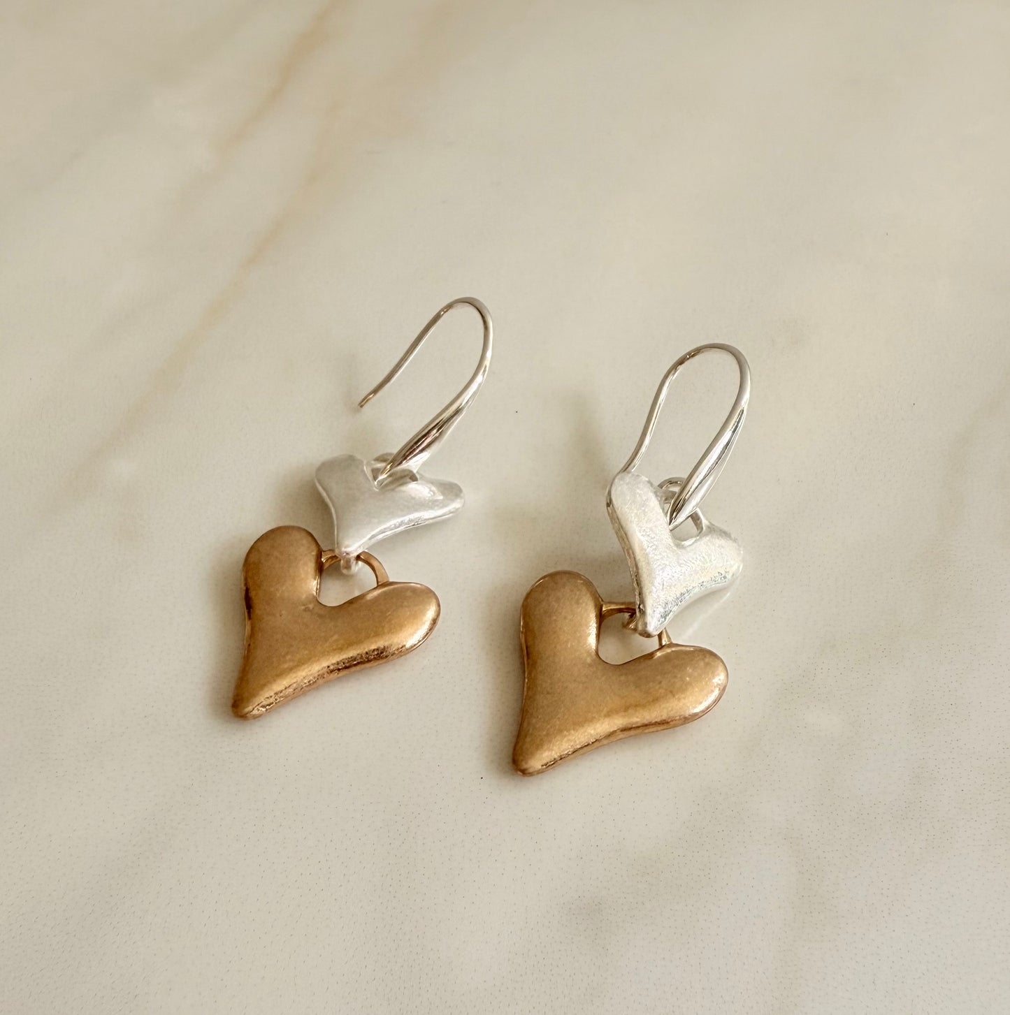 Silver plated and faux gold worn finish double heart drop earrings