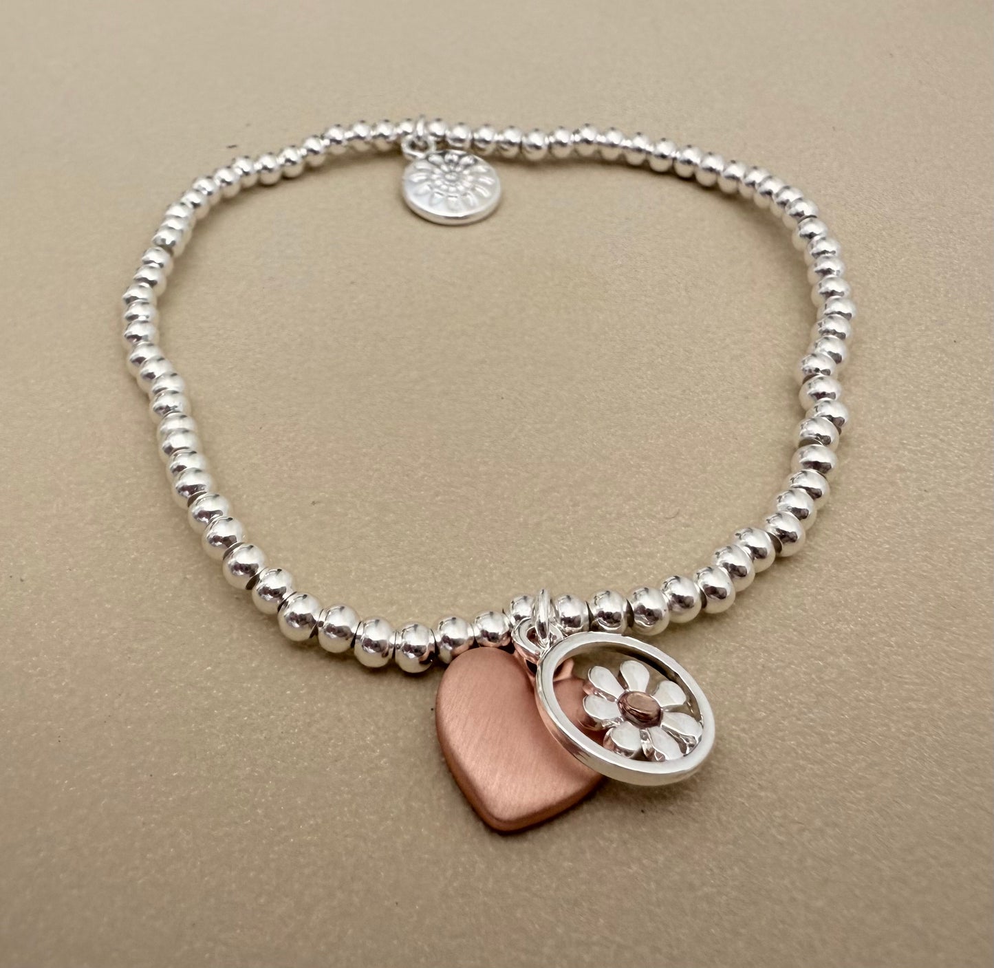 Silver plated stretch bracelet with daisy and heart charms